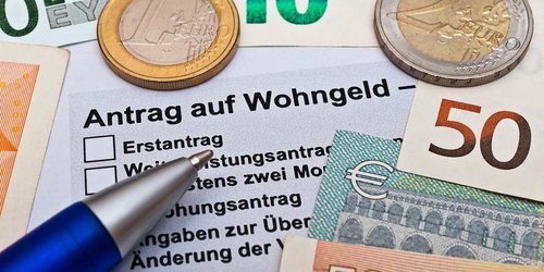 Wohngeldantrag mit Geld und einem Kugelschreiber