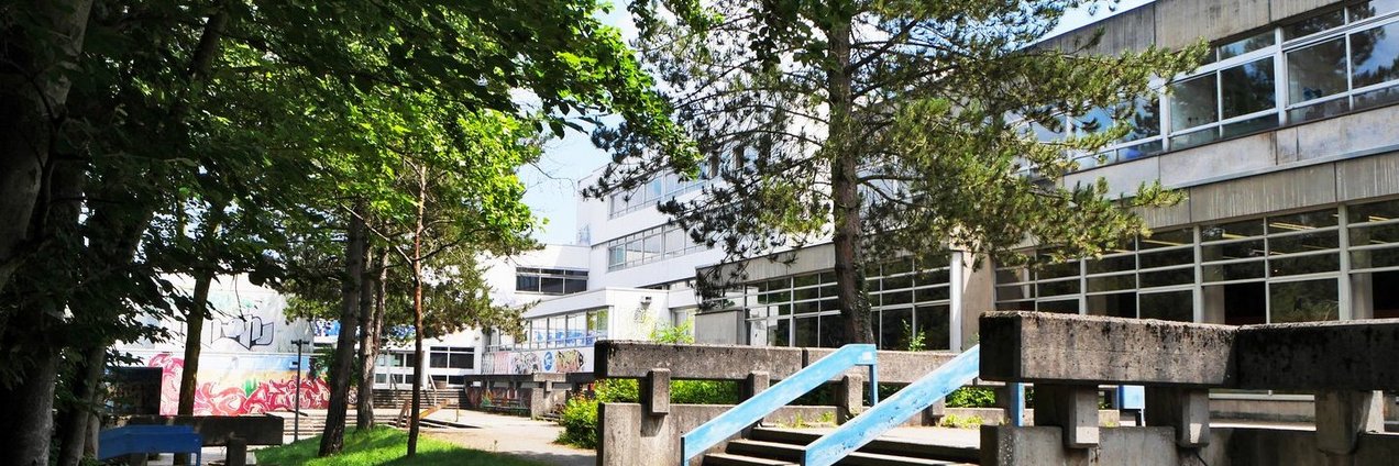 Schulgebäude und Schulhof mit Bäumen des Berufsbildungszentrum Marie Curie Völklingen