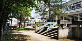 Schulgebäude und Schulhof mit Bäumen des Berufsbildungszentrum Marie Curie Völklingen