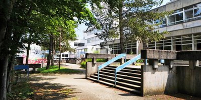 Schulgebäude und Schulhof mit Bäumen des Berufsbildungszentrum Marie Curie Völklingen
