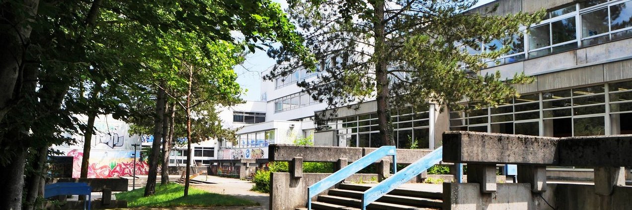 Schulgebäude und Schulhof mit Bäumen des Berufsbildungszentrum Marie Curie Völklingen