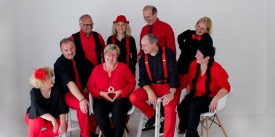 Sechs Frauen und vier Männer in schwarz-roter Kleidung vor weißem Hintergrund.