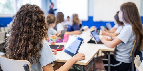 Mädchen mit ihren Tablets vor sich folgen dem Unterricht