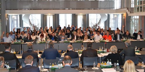 Festsaal mit parlamentarischer Bestuhlung, Mitglieder der Regionalversammlung stimmen ab per Handzeichen