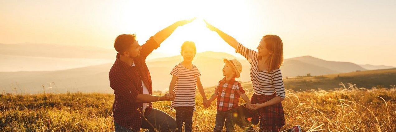 Glückliche Familie Eltern bilden ein schützendes Haus mit den Händen um ihre Kinder