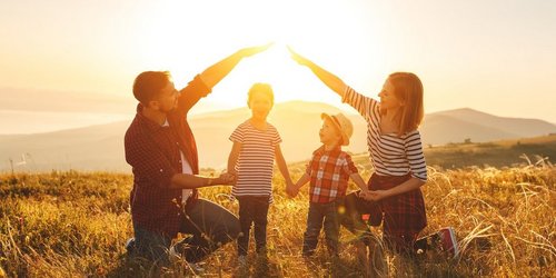 Eltern bilden ein schützendes Haus mit den Händen um ihre Kinder