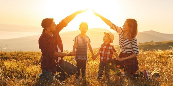 Eltern bilden ein schützendes Haus mit den Händen um ihre Kinder