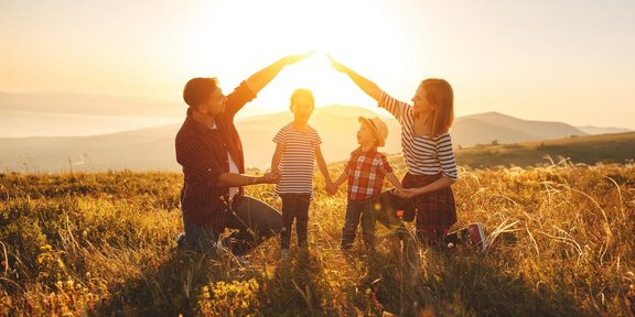 Eltern bilden ein schützendes Haus mit den Händen um ihre Kinder