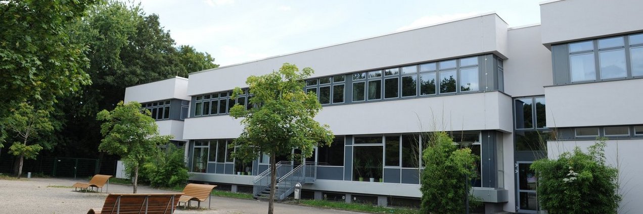 Schulgebäude und ein Teil des Schulhofes mit Parkbänken der Gemeinschaftsschule Bruchwiese