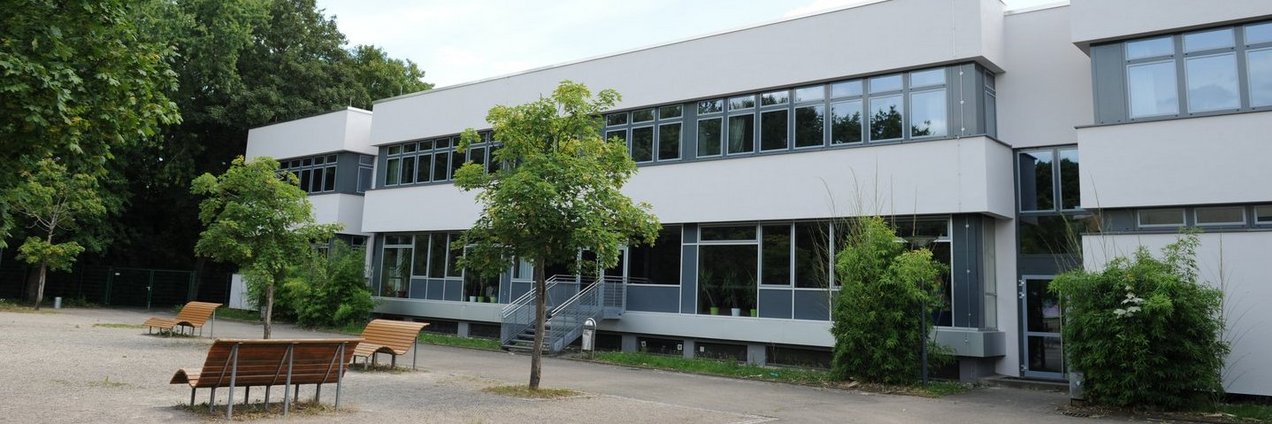 Schulgebäude und ein Teil des Schulhofes mit Parkbänken der Gemeinschaftsschule Bruchwiese