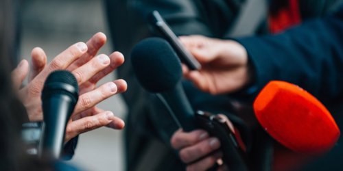 Interview mit Mikrofonen bei Pressekonferenz