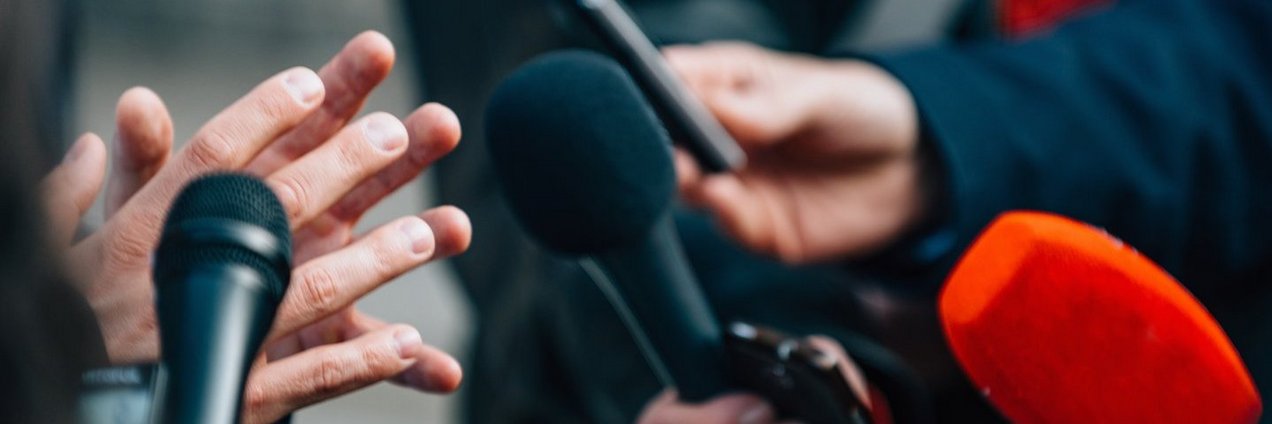 Interview mit Mikrofonen bei Pressekonferenz