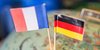 Frankreich- und Deutschlandflagge stecken in Miniaturform in einem Globus