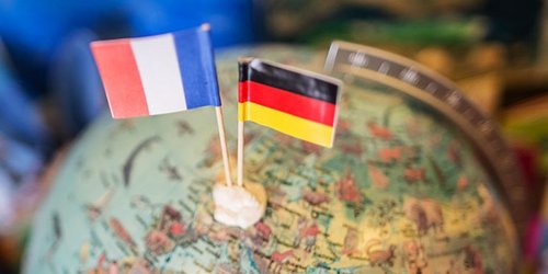 Frankreich- und Deutschlandflagge stecken in Miniaturform in einem Globus