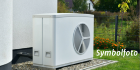 Eine Wärmepumpe im Garten eines Hauses. Auf dem Bild steht Symbolfoto