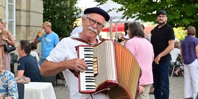 Mann mit Ziehharmonika lächelt in die Kamera