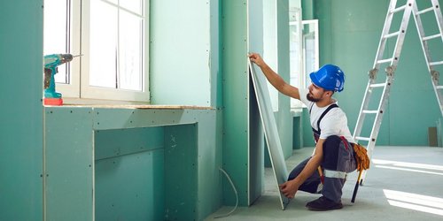 Bauarbeiter installiert Dämmplatten an einer Wand