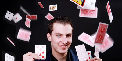 Maxim Maurice wirft Spielkarten in die Luft.