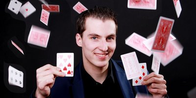 Maxim Maurice wirft Spielkarten in die Luft.