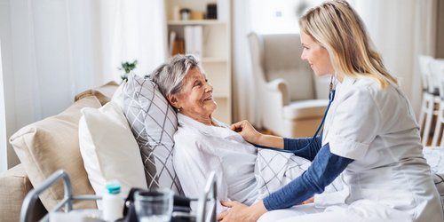 Eine junge Pflegerin kümmert sich um eine Seniorin