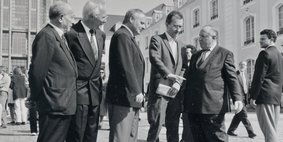 Politiker stehen zusammen in einer Gruppe auf dem Schlossplatz