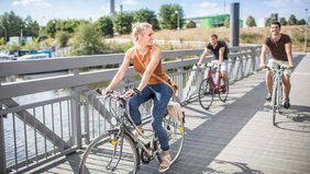 Drei Fahradfahrende Menschen am Saarbrücker Osthafen