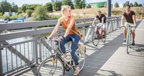Drei Fahradfahrende Menschen am Saarbrücker Osthafen