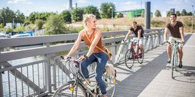 Drei Fahradfahrende Menschen am Saarbrücker Osthafen