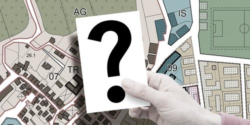 Landkarte, Baugesetzbuch und ein Aktenordner auf einem Bürotisch